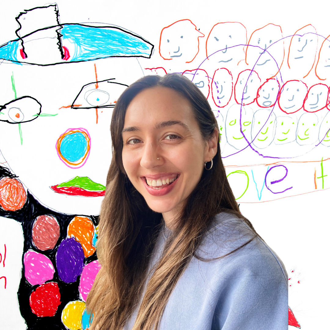 A photo of staff member Stephanie Kelley. She has long brown hair, brown eyes and she is smiling. She is wearing a light blue jumper. The background is a colourful drawing of a clown at the circus, by member Errol Drysdale.
